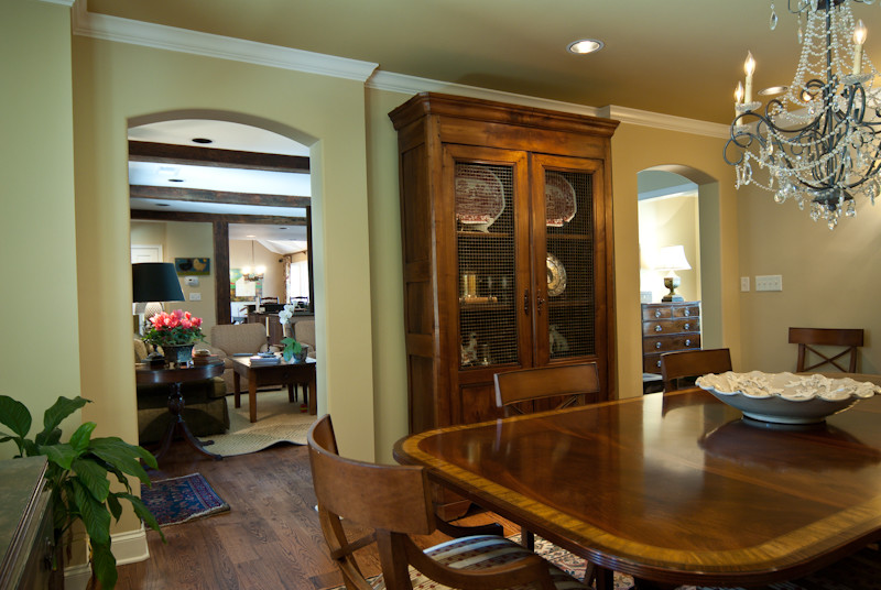 Example of a large mountain style medium tone wood floor kitchen/dining room combo design with beige walls, a standard fireplace and a stone fireplace
