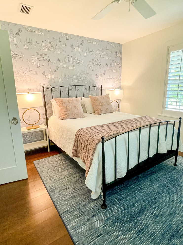 Ejemplo de habitación de invitados costera con suelo de madera en tonos medios y papel pintado