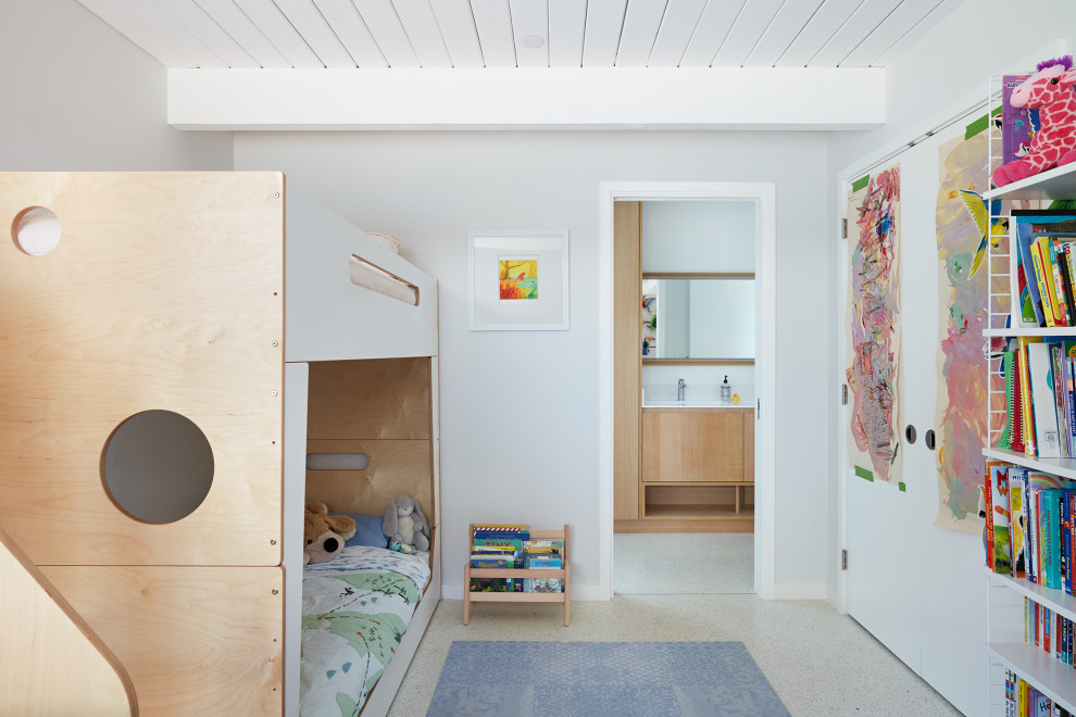 This is an example of a midcentury kids' bedroom for kids 4-10 years old in San Francisco with white walls, white floor and timber.