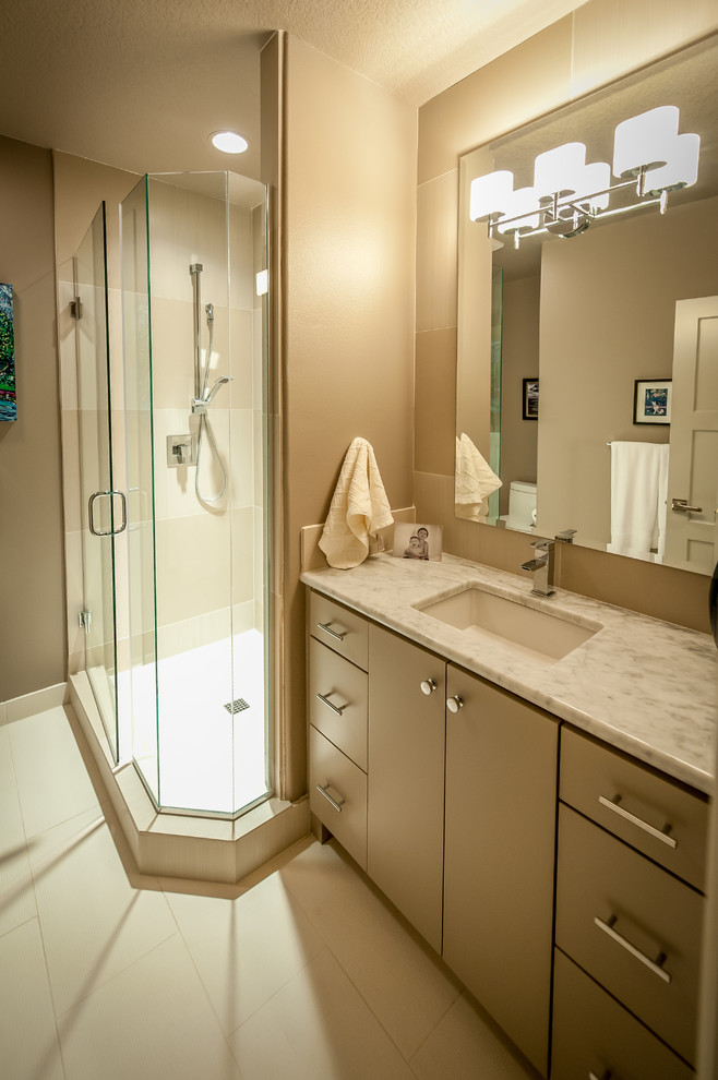 This is an example of a transitional bathroom in Portland with an undermount sink, flat-panel cabinets, beige cabinets, marble benchtops, an open shower, gray tile and porcelain tile.