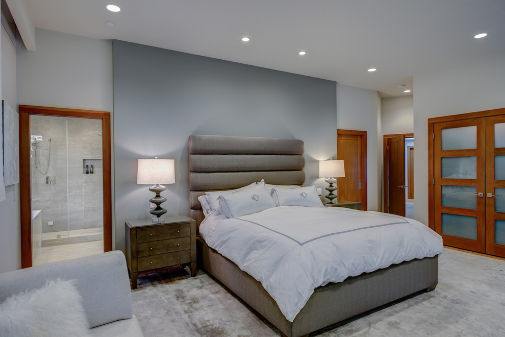 This is an example of a large contemporary master bedroom in San Francisco with grey walls, light hardwood floors and no fireplace.