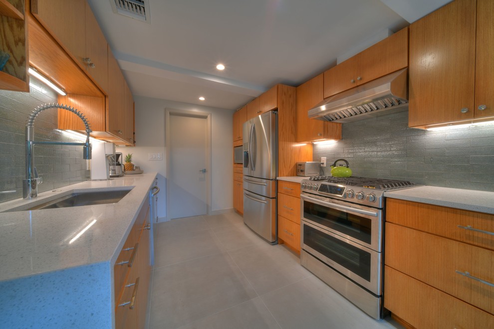 Inspiration for a mid-sized midcentury galley separate kitchen in Miami with an undermount sink, flat-panel cabinets, medium wood cabinets, limestone benchtops, grey splashback, cement tile splashback, stainless steel appliances, concrete floors, no island, grey floor and beige benchtop.