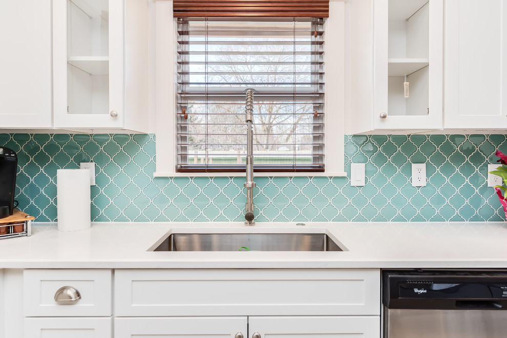 Small transitional l-shaped porcelain tile and gray floor eat-in kitchen photo in Boise with a single-bowl sink, shaker cabinets, white cabinets, quartz countertops, blue backsplash, glass tile backsplash, stainless steel appliances and an island