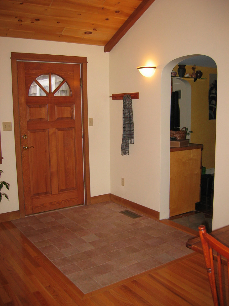 Idée de décoration pour une entrée bohème de taille moyenne avec un vestiaire, un mur blanc, un sol en carrelage de céramique, une porte simple, une porte en bois brun, un sol rose et un plafond en lambris de bois.