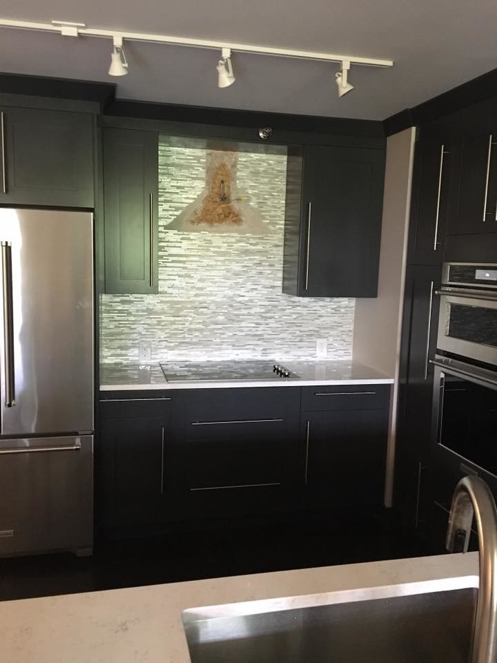 Example of a mid-sized transitional u-shaped kitchen design in New York with an undermount sink, shaker cabinets, dark wood cabinets, quartz countertops, gray backsplash, matchstick tile backsplash, stainless steel appliances and white countertops