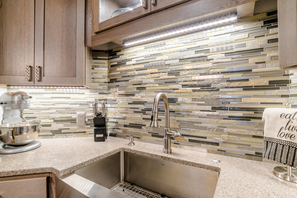 Mid-sized transitional u-shaped medium tone wood floor enclosed kitchen photo in Miami with a farmhouse sink, shaker cabinets, gray cabinets, quartz countertops, gray backsplash, glass tile backsplash, white appliances and an island