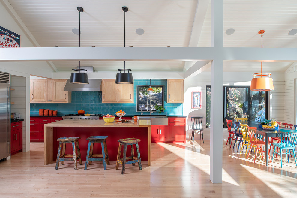 Eclectic l-shaped eat-in kitchen in Minneapolis with a farmhouse sink, shaker cabinets, red cabinets, wood benchtops, blue splashback, stainless steel appliances, light hardwood floors, with island, beige floor and beige benchtop.