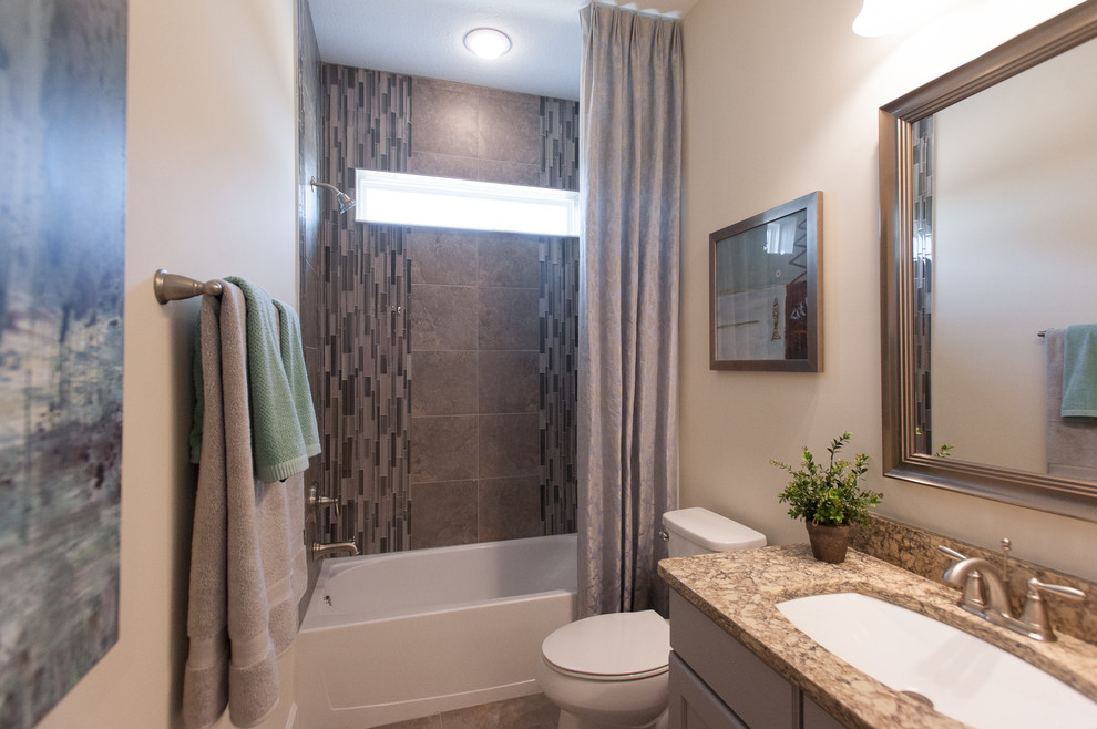 This is an example of a large transitional kids bathroom in Jacksonville with flat-panel cabinets, brown cabinets, an alcove tub, a corner shower, a one-piece toilet, beige tile, ceramic tile, beige walls, ceramic floors, a drop-in sink and soapstone benchtops.