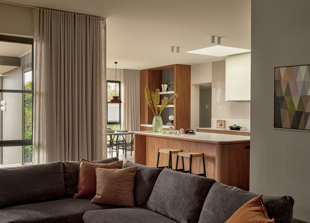 Design ideas for an expansive midcentury l-shaped open plan kitchen in Sydney with a double-bowl sink, flat-panel cabinets, medium wood cabinets, porcelain floors and with island.