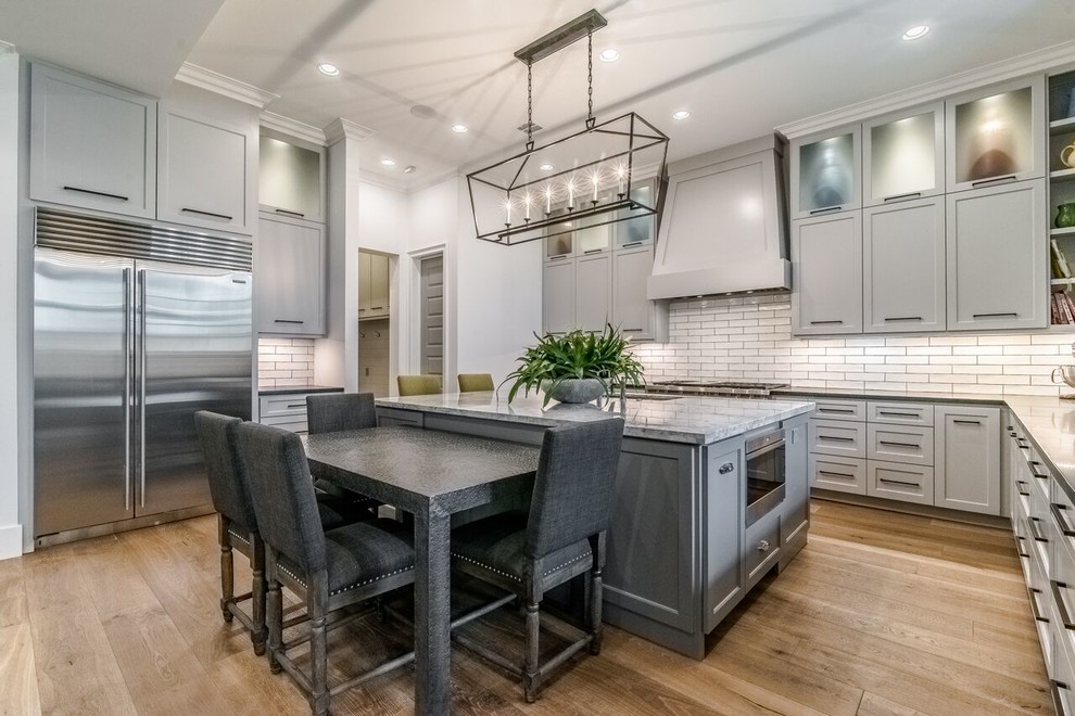 Design ideas for a large transitional u-shaped open plan kitchen in Houston with shaker cabinets, grey cabinets, quartzite benchtops, white splashback and with island.