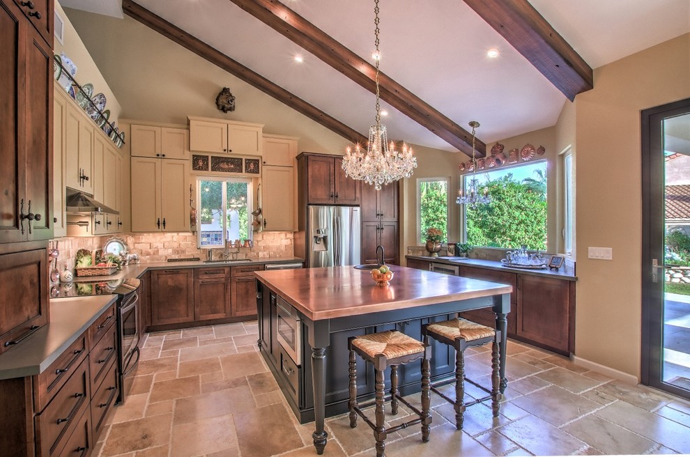 Mid-sized eclectic eat-in kitchen in Phoenix with a single-bowl sink, shaker cabinets, black cabinets, copper benchtops, beige splashback, travertine splashback, stainless steel appliances, porcelain floors, with island and beige floor.