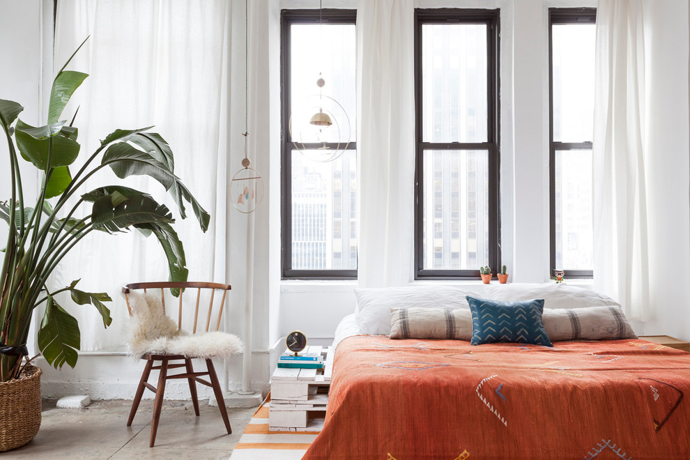 Design ideas for an industrial bedroom in New York with white walls and concrete floors.