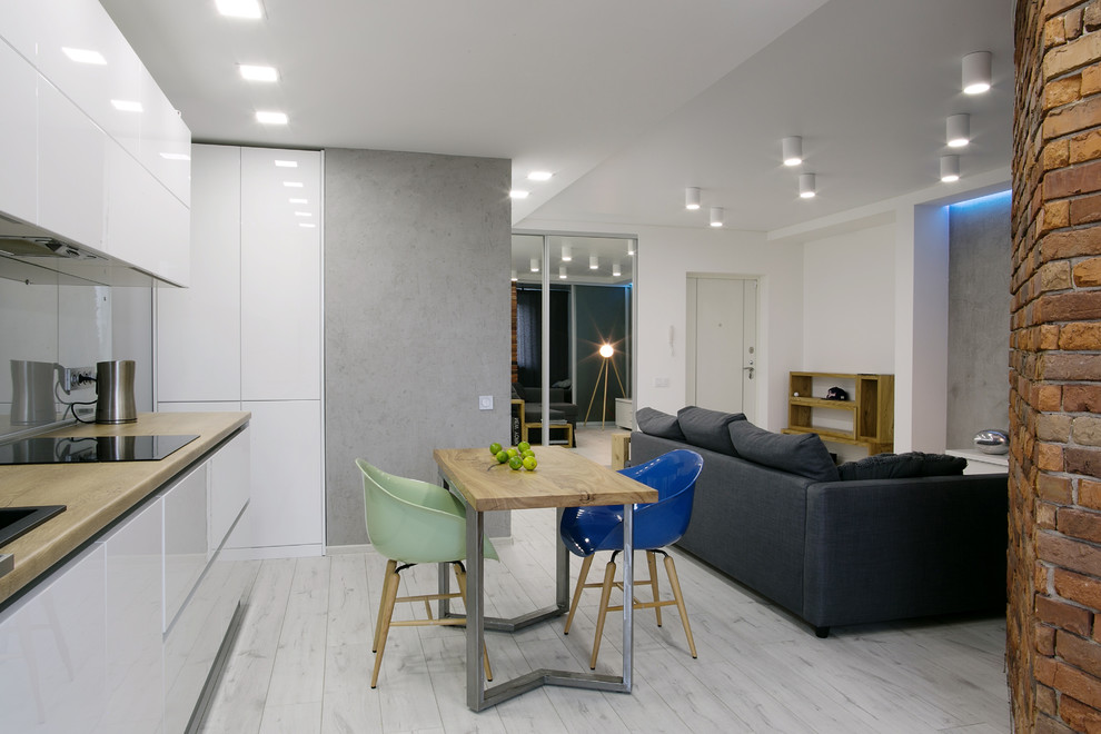 Design ideas for a mid-sized contemporary single-wall open plan kitchen in Moscow with a drop-in sink, flat-panel cabinets, white cabinets, laminate benchtops, grey splashback, glass sheet splashback, stainless steel appliances and no island.