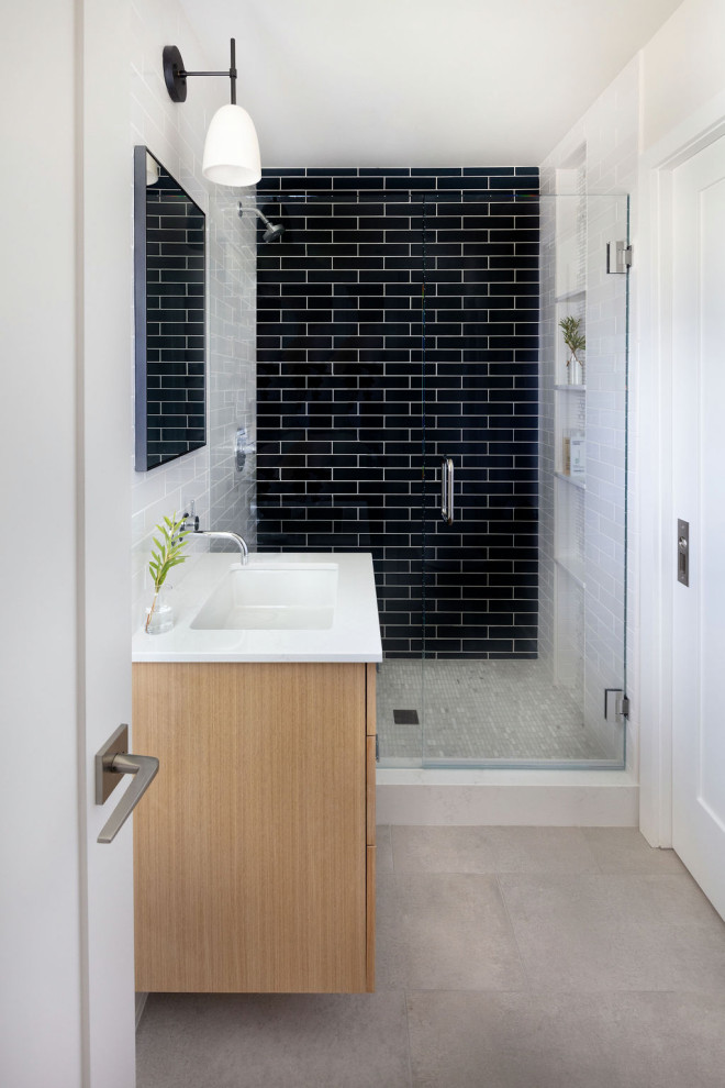Источник вдохновения для домашнего уюта: маленькая ванная комната, совмещенная с туалетом в современном стиле с плоскими фасадами, светлыми деревянными фасадами, душем, белой плиткой, керамической плиткой, белыми стенами, полом из керамогранита, врезной раковиной, столешницей из искусственного кварца, серым полом, душем с распашными дверями, белой столешницей и тумбой под одну раковину для на участке и в саду