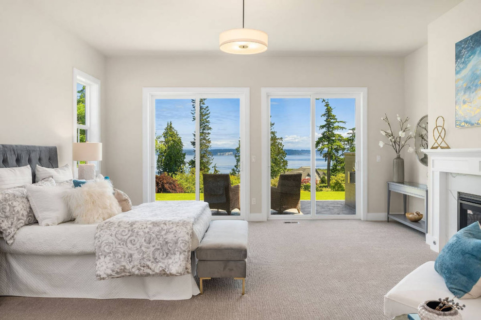 This is an example of a large beach style master bedroom in Seattle with white walls, carpet, a standard fireplace, a concrete fireplace surround, grey floor, coffered and wallpaper.