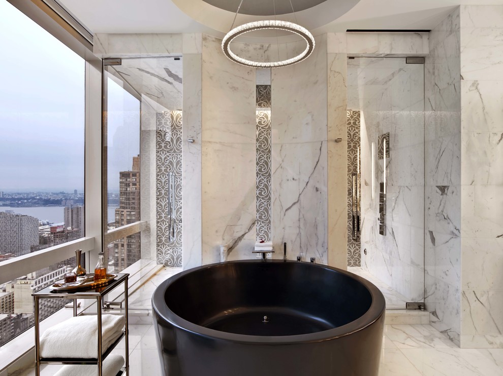 Design ideas for a contemporary master bathroom in New York with a freestanding tub and marble floors.