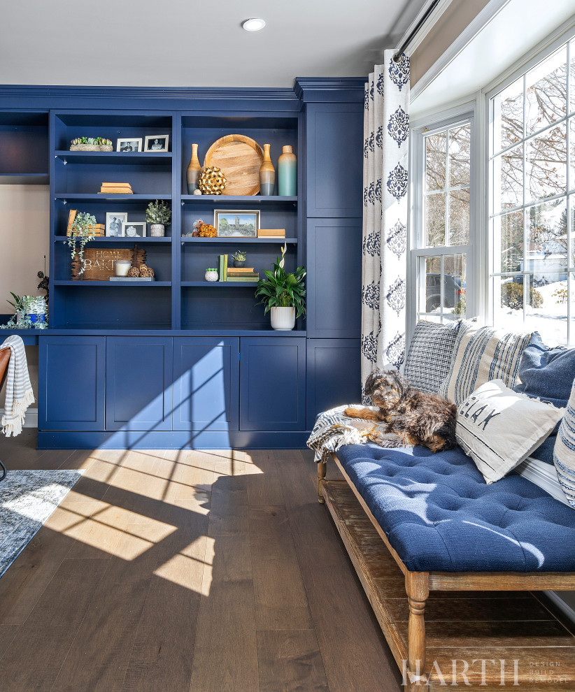 Immagine di un soggiorno chic di medie dimensioni e chiuso con libreria, pareti beige, pavimento in legno massello medio, parete attrezzata e pavimento marrone