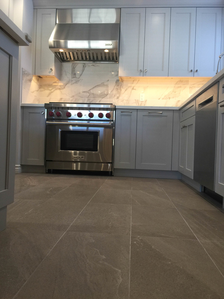 Example of a mid-sized transitional u-shaped porcelain tile and gray floor eat-in kitchen design in San Francisco with an undermount sink, recessed-panel cabinets, gray cabinets, quartz countertops, gray backsplash, porcelain backsplash, stainless steel appliances and white countertops