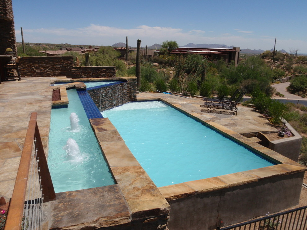 Inspiration for a large backyard custom-shaped infinity pool fountain remodel in Phoenix with decking