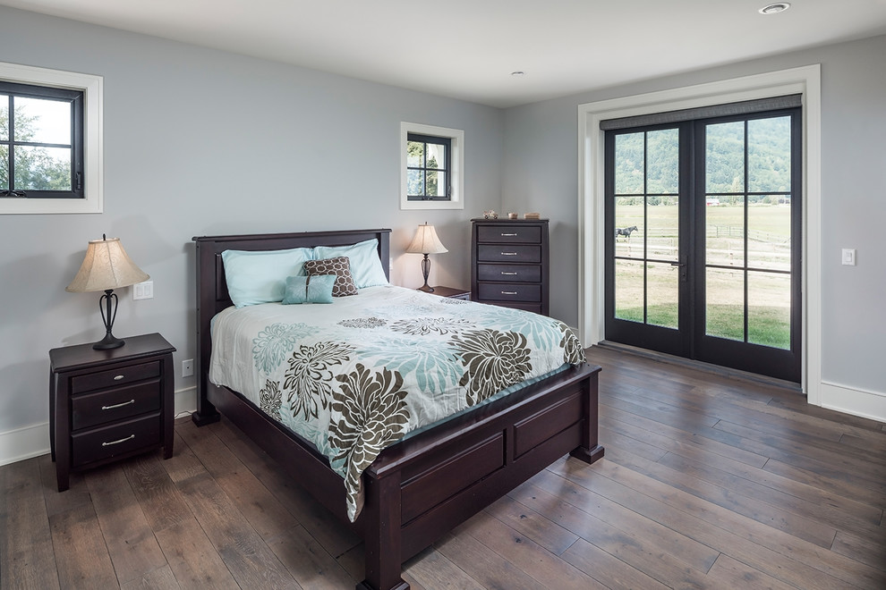 This is an example of a large country master bedroom in Vancouver with grey walls, dark hardwood floors and brown floor.