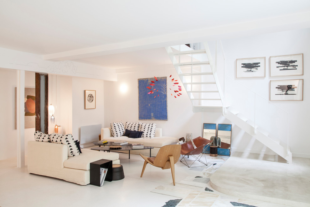 Photo of a contemporary open concept living room in Paris with white walls and white floor.
