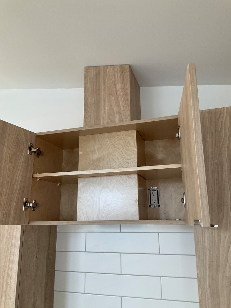 Open light wood kitchen cabinet with interior power outlet
