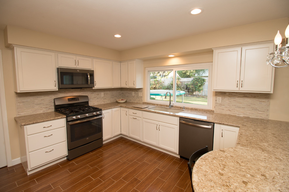 Open concept kitchen - mid-sized transitional u-shaped porcelain tile open concept kitchen idea with an undermount sink, recessed-panel cabinets, beige cabinets, quartz countertops, beige backsplash, mosaic tile backsplash and colored appliances