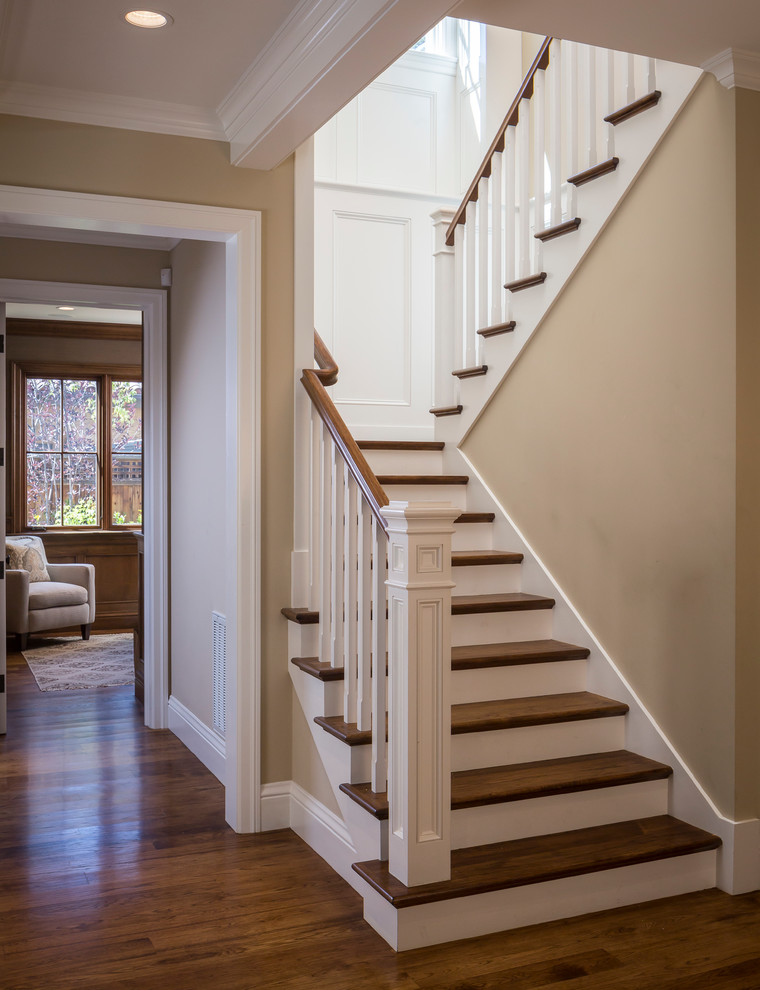 This is an example of a mid-sized traditional wood u-shaped staircase in San Francisco with painted wood risers and wood railing.