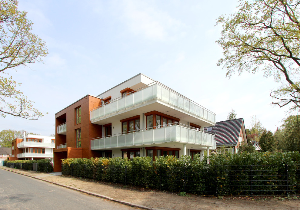 Mittelgroßes, Zweistöckiges Modernes Wohnung mit Flachdach, Putzfassade, weißer Fassadenfarbe und Wandpaneelen in Hamburg