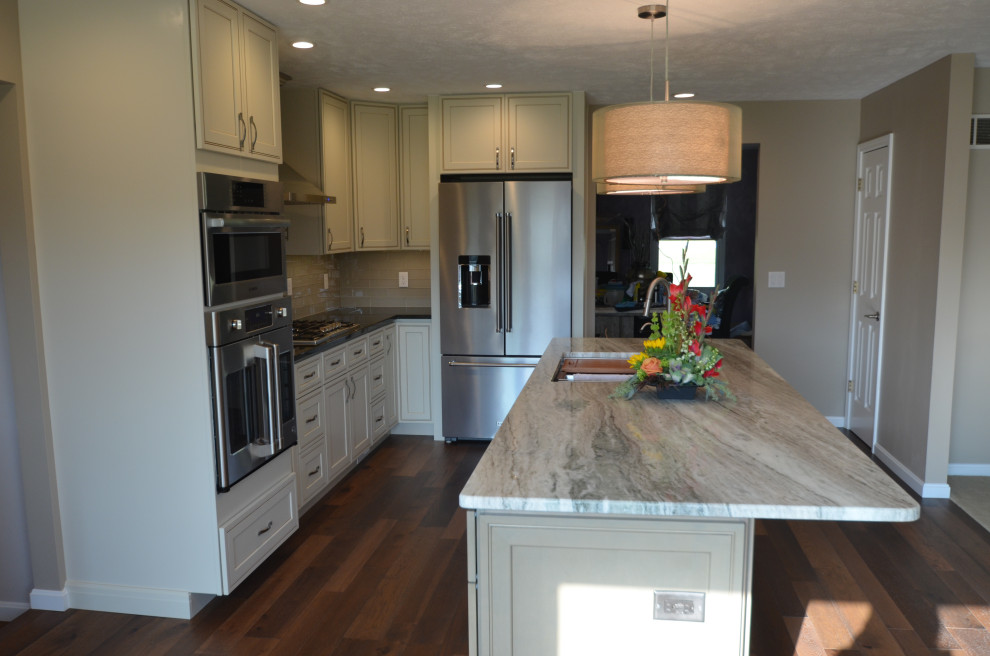 Eat-in kitchen - mid-sized transitional u-shaped medium tone wood floor and brown floor eat-in kitchen idea with an undermount sink, raised-panel cabinets, beige cabinets, granite countertops, multicolored backsplash, mosaic tile backsplash, stainless steel appliances, an island and multicolored countertops