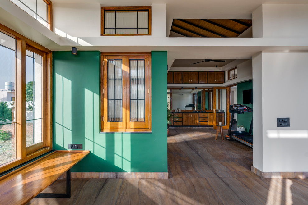 This is an example of a large contemporary multi-use home gym in Hyderabad with green walls, limestone flooring, multi-coloured floors and a wood ceiling.