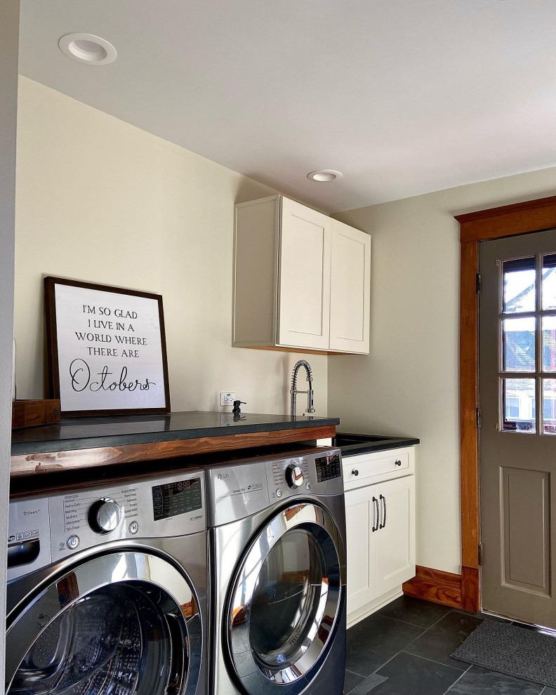 Design ideas for a mid-sized traditional laundry room in Chicago with shaker cabinets, white cabinets, soapstone benchtops, beige walls, a side-by-side washer and dryer and black benchtop.
