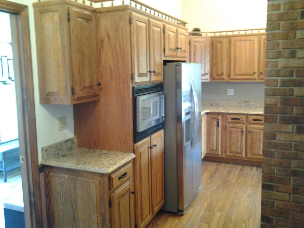 Enclosed kitchen - mid-sized rustic medium tone wood floor enclosed kitchen idea in Indianapolis with an undermount sink, raised-panel cabinets, medium tone wood cabinets, quartzite countertops, stainless steel appliances and no island