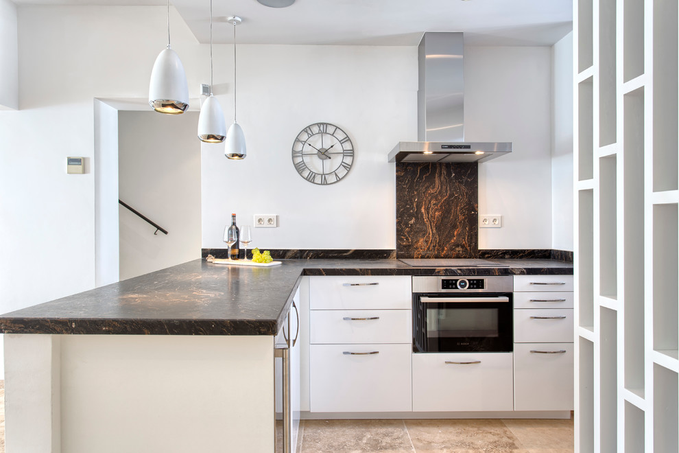 Inspiration for a mid-sized contemporary l-shaped open plan kitchen in Malaga with flat-panel cabinets, white cabinets, white splashback, stainless steel appliances and no island.