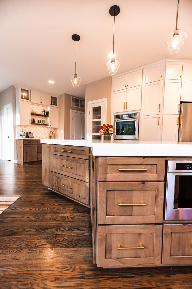 Eat-in kitchen - mid-sized transitional l-shaped dark wood floor and brown floor eat-in kitchen idea in Baltimore with a single-bowl sink, shaker cabinets, white cabinets, quartz countertops, white backsplash, marble backsplash, stainless steel appliances, an island and white countertops