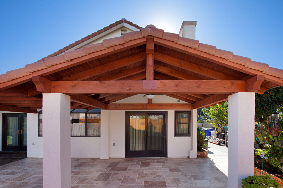 Large traditional two-storey adobe beige house exterior in San Diego with a gambrel roof, a tile roof and a red roof.