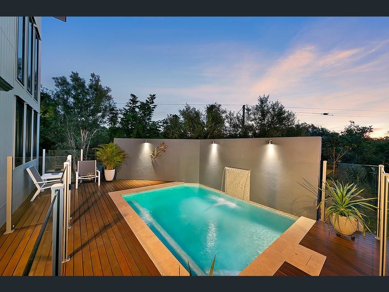 Mid-sized modern courtyard rectangular lap pool in Brisbane with a water feature and decking.