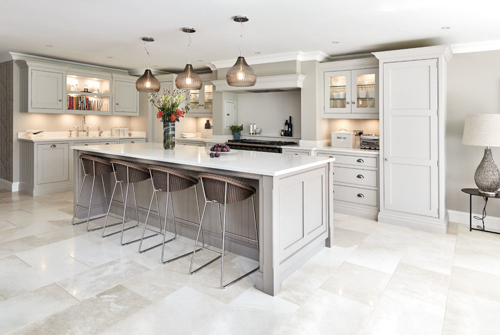 This is an example of a mid-sized transitional l-shaped kitchen in Manchester with shaker cabinets, grey cabinets, with island, beige floor and white benchtop.