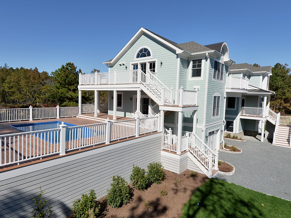 Large beach style three-storey blue exterior in Other with concrete fiberboard siding and a gable roof.