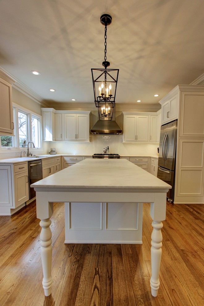 Large transitional u-shaped light wood floor kitchen pantry photo in Atlanta with an undermount sink, recessed-panel cabinets, white cabinets, quartz countertops, white backsplash, subway tile backsplash, stainless steel appliances and an island