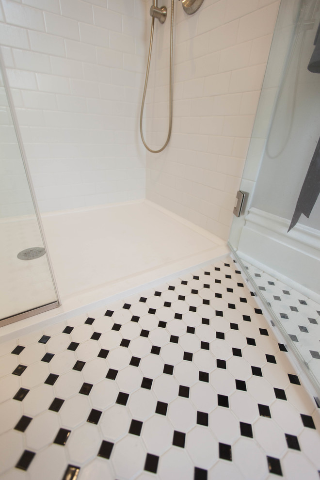 This is an example of a mid-sized transitional 3/4 bathroom in St Louis with shaker cabinets, black cabinets, an alcove shower, a two-piece toilet, black and white tile, porcelain tile, grey walls, porcelain floors, an undermount sink and engineered quartz benchtops.