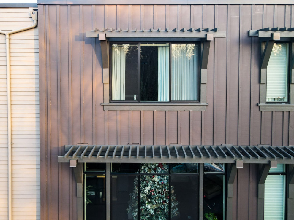 Идея дизайна: трехэтажный, коричневый таунхаус среднего размера в стиле модернизм с облицовкой из цементной штукатурки, плоской крышей, крышей из смешанных материалов, коричневой крышей и отделкой доской с нащельником