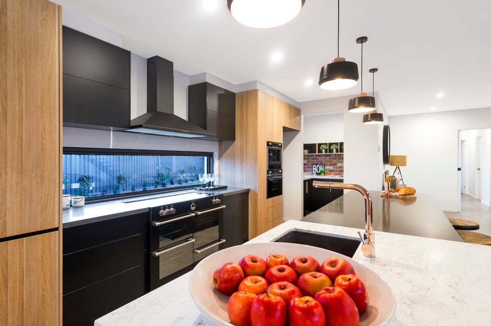 Design ideas for an expansive contemporary galley open plan kitchen in Canberra - Queanbeyan with an undermount sink, beaded inset cabinets, black cabinets, marble benchtops, window splashback, black appliances, ceramic floors and with island.