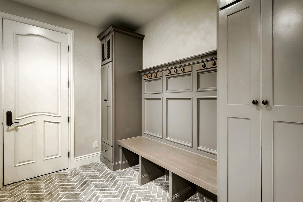 Photo of a large mudroom in Denver with grey walls, brick floors and grey floor.