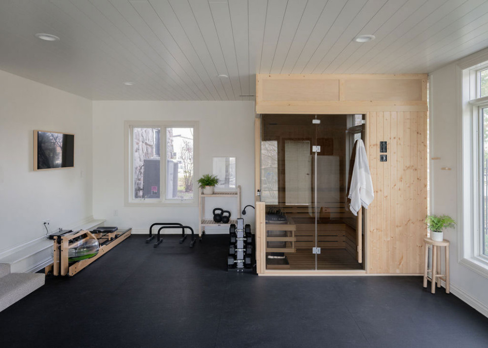 Idées déco pour une salle de musculation classique avec un mur blanc, un sol noir et un plafond en lambris de bois.