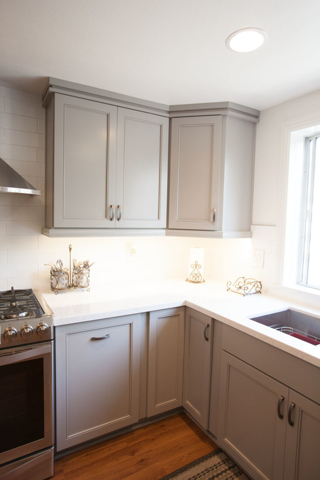 Large transitional u-shaped dark wood floor eat-in kitchen photo in Los Angeles with an undermount sink, recessed-panel cabinets, gray cabinets, quartz countertops, white backsplash, subway tile backsplash, stainless steel appliances and no island