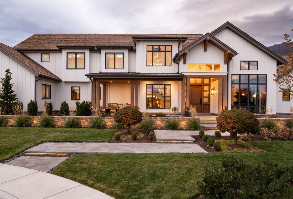 Expansive country two-storey white house exterior in Salt Lake City with wood siding, a gable roof and a shingle roof.