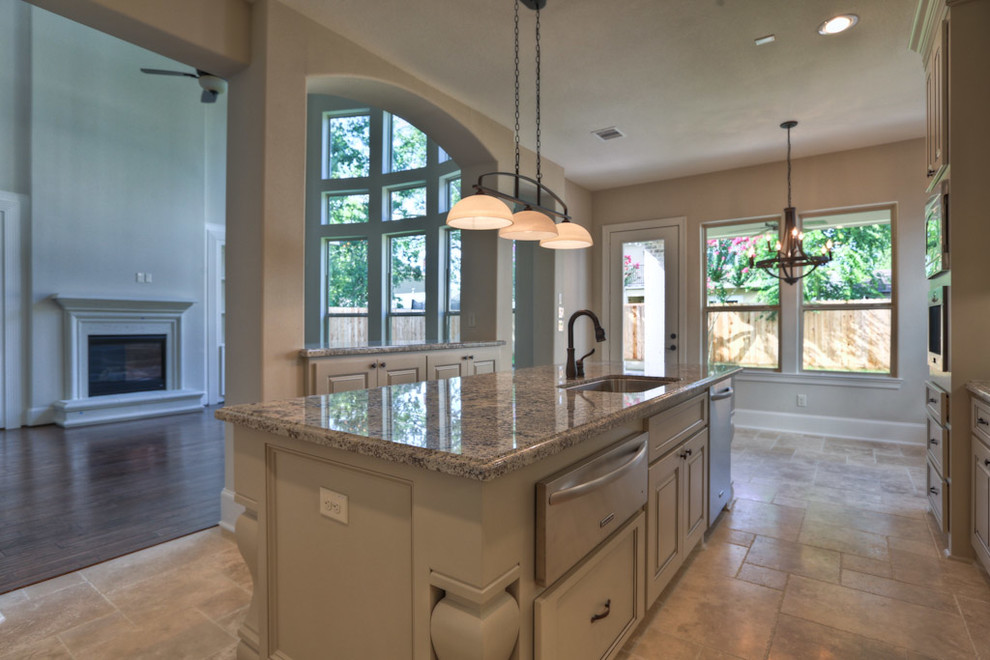 Inspiration for a traditional l-shaped eat-in kitchen in Houston with a single-bowl sink, beige cabinets, granite benchtops, beige splashback, stone tile splashback and stainless steel appliances.