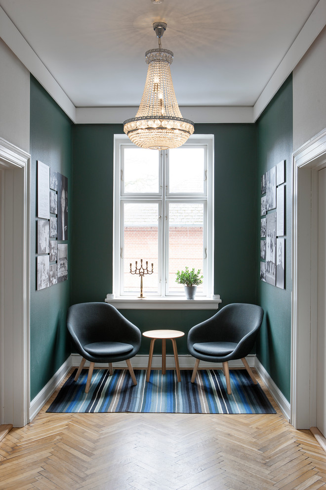 Traditional hallway in Copenhagen with green walls and medium hardwood floors.
