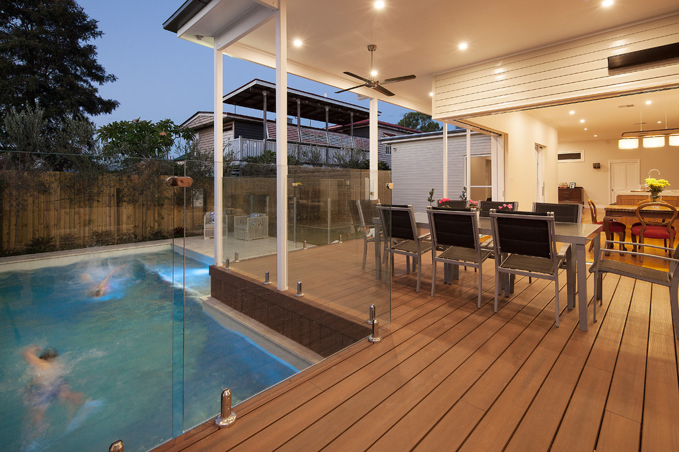 Design ideas for a transitional backyard deck in Brisbane with a roof extension.